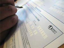 Close up of someone filling out a direct debit form to pay bills (http://www.bbc.co.uk/schools/gcsebitesize/business/images/bills_cashflow.jpg)