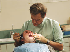 A still from the Armstrong & Miller show, a dentist is looking inside a patients mouth. (http://www.bbc.co.uk/schools/gcsebitesize/business/images/dentist1.jpg)